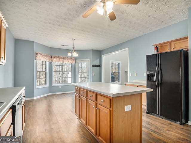 1301 Crosswind Pl, Mcdonough, GA 30252 - kitchen with dishwasher, a center island, black fridge, and dark wood-style floors
