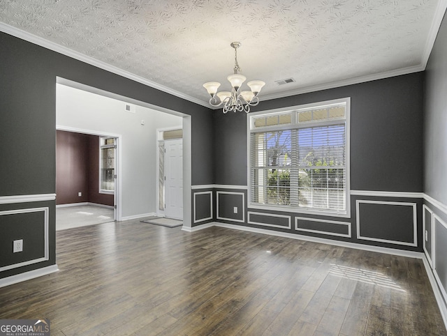 1301 Crosswind Pl, Mcdonough, GA 30252 - empty room with an inviting chandelier, a textured ceiling, ornamental molding, visible vents, and hardwood / wood-style floors