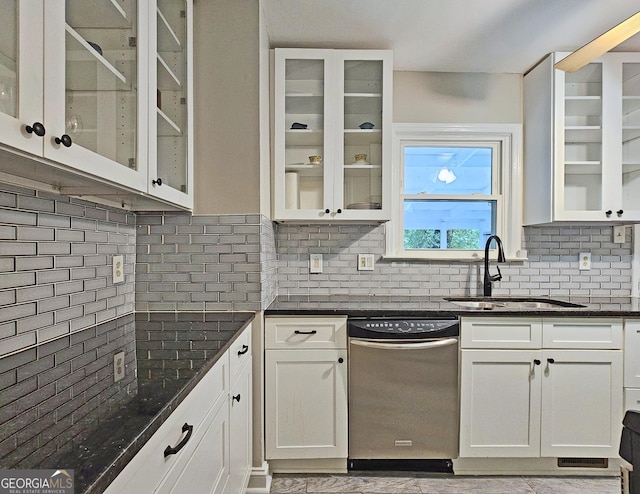 kitchen featuring white cabinetry, sink, dark stone countertops, decorative backsplash, and stainless steel dishwasher