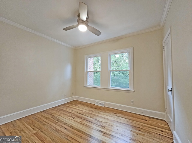 spare room featuring ornamental molding, ceiling fan, and light wood-type flooring