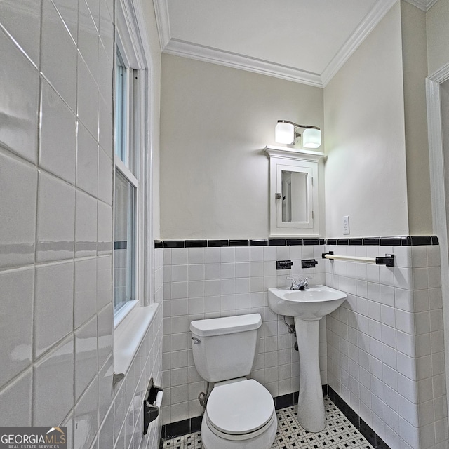 bathroom featuring ornamental molding, toilet, and tile walls