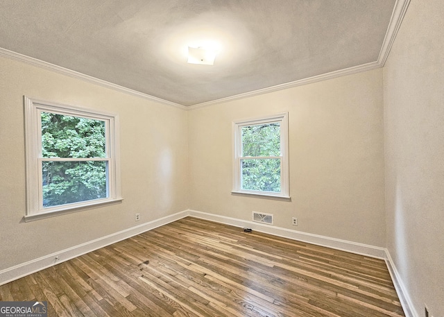 spare room featuring ornamental molding and hardwood / wood-style floors