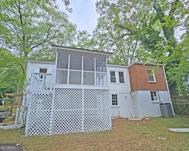 rear view of house featuring a sunroom and central AC unit