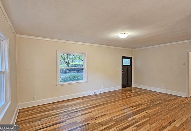 empty room featuring crown molding and hardwood / wood-style floors