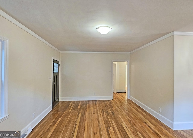 unfurnished room with wood-type flooring and ornamental molding