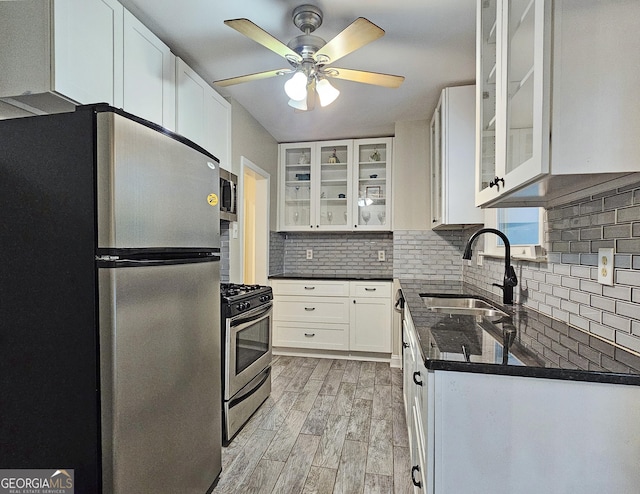 kitchen featuring appliances with stainless steel finishes, sink, decorative backsplash, and white cabinets