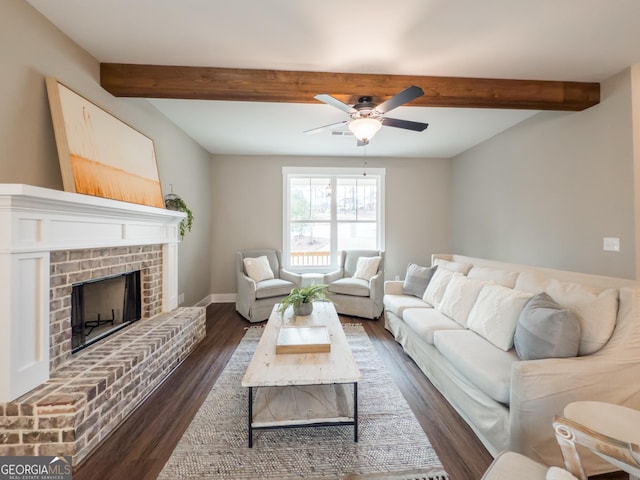 living room featuring beamed ceiling, ceiling fan, dark hardwood / wood-style floors, and a fireplace