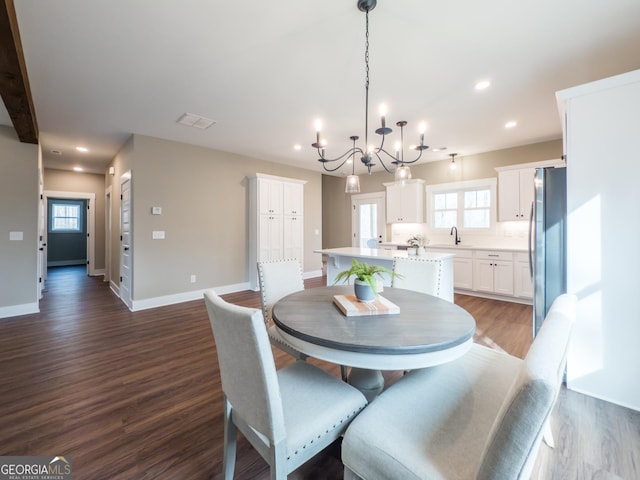 dining room featuring sink and dark wood-type flooring