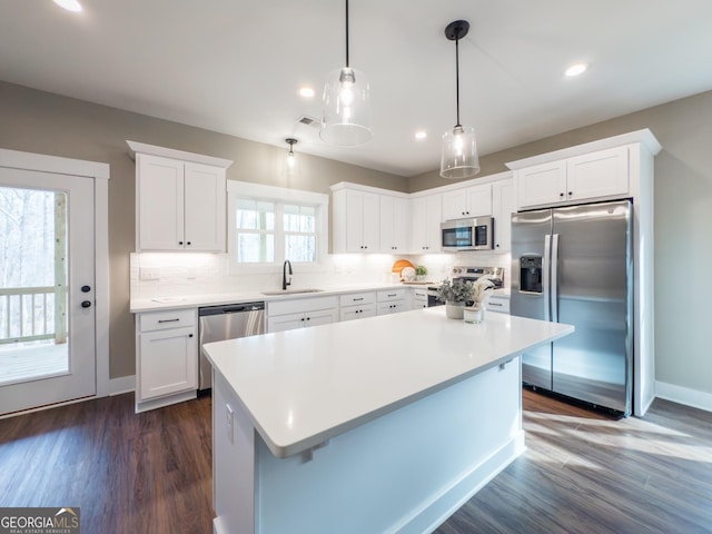 kitchen featuring sink, decorative light fixtures, white cabinets, and appliances with stainless steel finishes