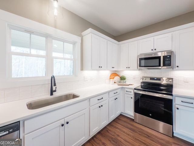 kitchen featuring dark wood-type flooring, sink, stainless steel appliances, decorative backsplash, and white cabinets