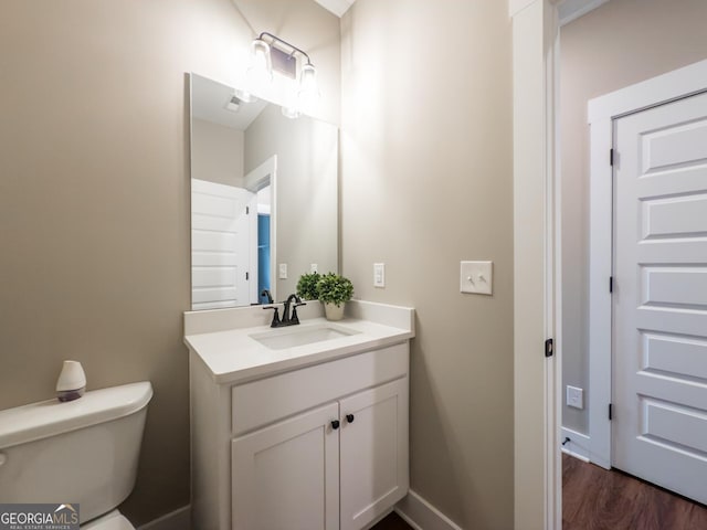 bathroom featuring vanity, hardwood / wood-style floors, and toilet