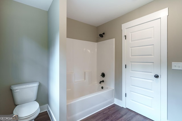 bathroom with shower / washtub combination, toilet, and wood-type flooring