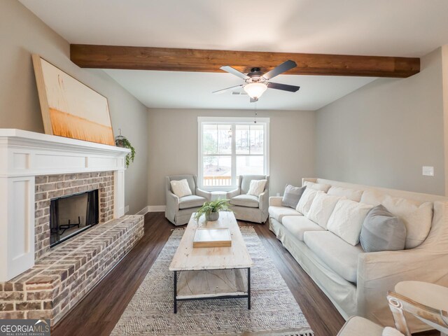 living room with beam ceiling, ceiling fan, a fireplace, and dark hardwood / wood-style flooring