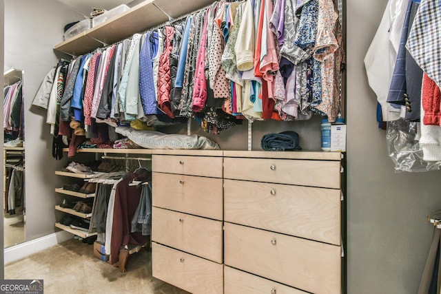 spacious closet featuring light colored carpet