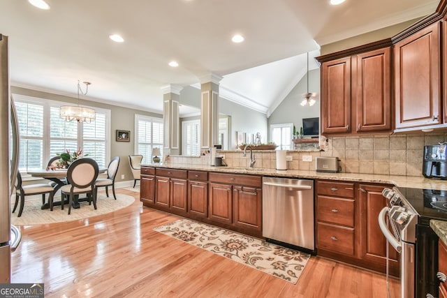 kitchen featuring decorative backsplash, stainless steel appliances, vaulted ceiling, pendant lighting, and an inviting chandelier