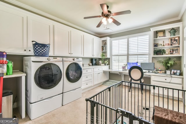 clothes washing area featuring ceiling fan, cabinets, light carpet, washer and clothes dryer, and ornamental molding