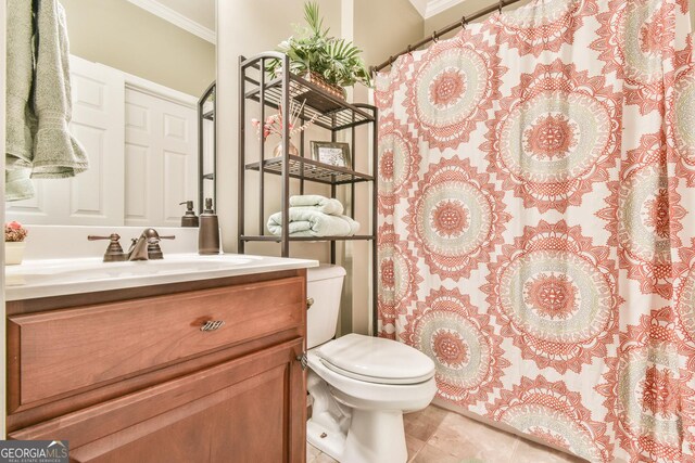 bathroom with tile patterned floors, vanity, toilet, and crown molding