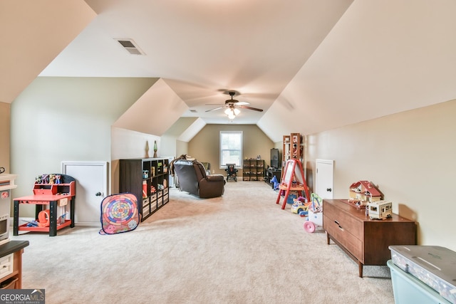 rec room with ceiling fan, light colored carpet, and vaulted ceiling