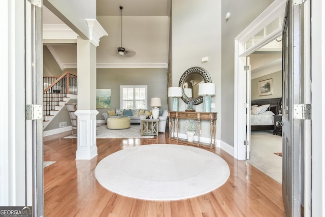 dining space with decorative columns, hardwood / wood-style flooring, and ornamental molding