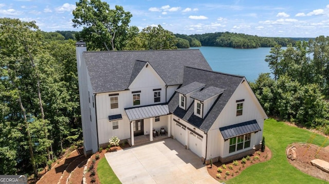 view of front facade with a water view, a front lawn, and a garage