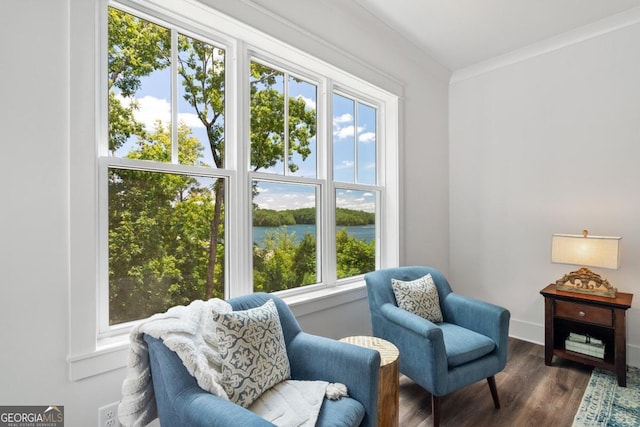 living area with dark wood-type flooring, crown molding, a healthy amount of sunlight, and a water view