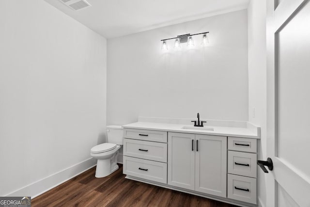 bathroom with vanity, hardwood / wood-style flooring, and toilet