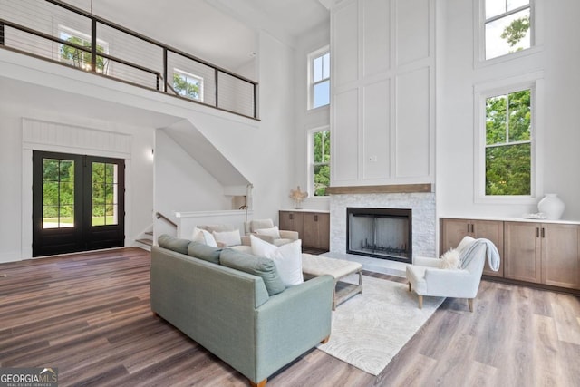 living room with a high ceiling, hardwood / wood-style flooring, and a healthy amount of sunlight