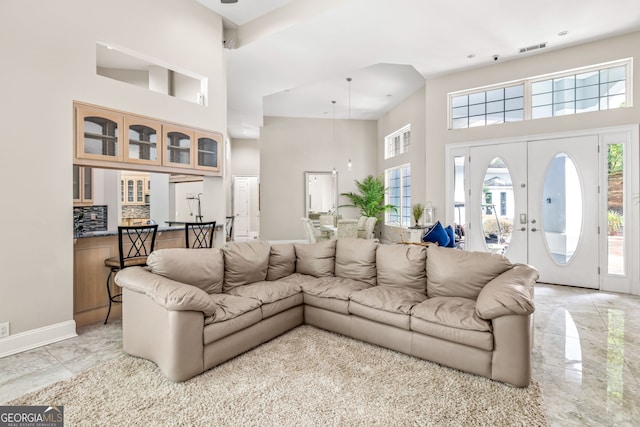 living room featuring a towering ceiling and french doors