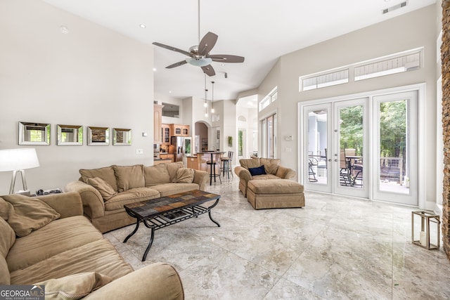 living room featuring french doors, ceiling fan, and a high ceiling