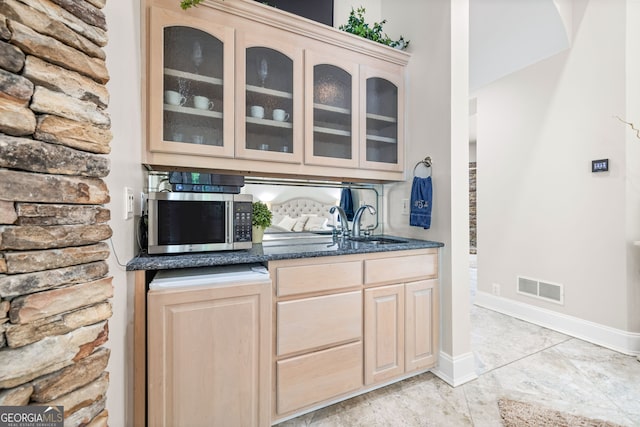 bar with sink and light brown cabinets