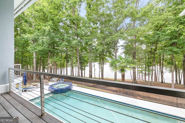 view of swimming pool featuring an in ground hot tub and a water view