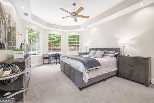 bedroom featuring multiple windows, light carpet, and ceiling fan