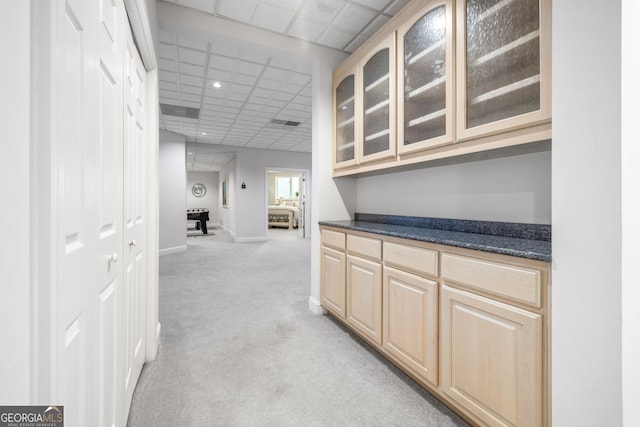 hallway featuring light carpet and a drop ceiling