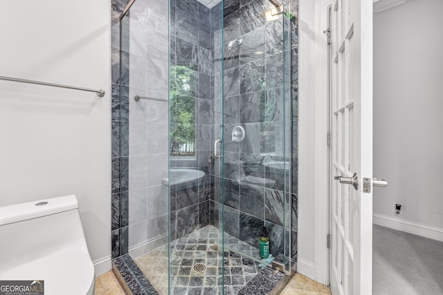 bathroom with toilet and a shower with shower door