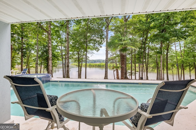 view of swimming pool featuring an in ground hot tub and a water view