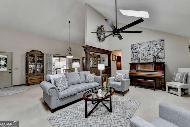 carpeted living room featuring a skylight, high vaulted ceiling, and ceiling fan