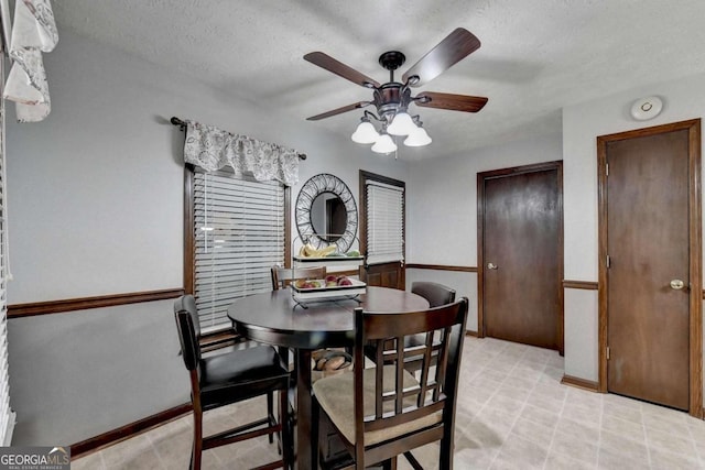 dining room featuring ceiling fan and a textured ceiling