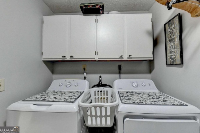 laundry area with cabinets, independent washer and dryer, and a textured ceiling