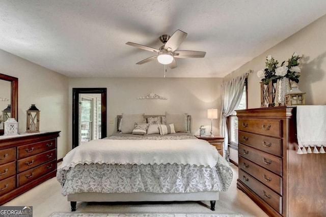 carpeted bedroom featuring multiple windows and ceiling fan