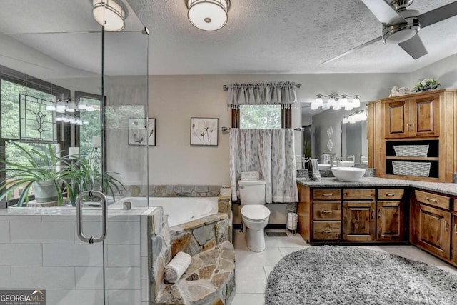 bathroom with a bathing tub, ceiling fan, tile patterned floors, a textured ceiling, and vanity