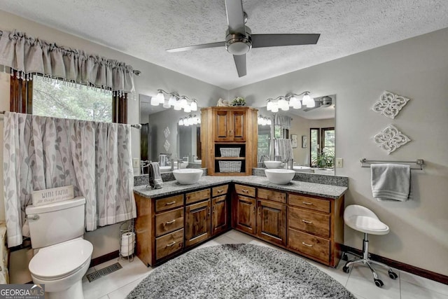 bathroom with vanity, tile patterned floors, ceiling fan, toilet, and a textured ceiling