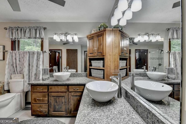 bathroom with ceiling fan, an enclosed shower, a textured ceiling, toilet, and vanity