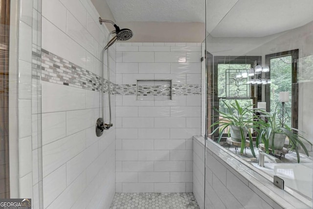 bathroom featuring tiled shower and a textured ceiling