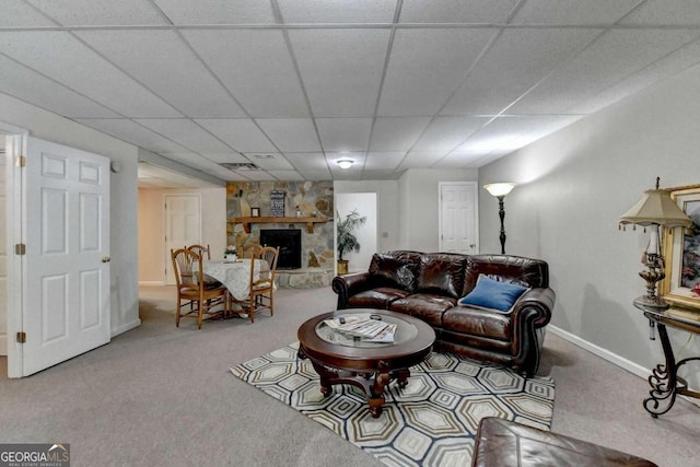 living room with a paneled ceiling, a fireplace, and carpet