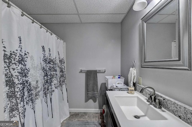 bathroom featuring a paneled ceiling and vanity