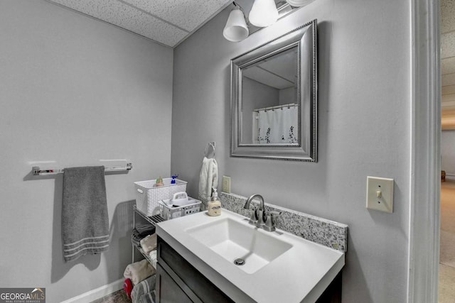 bathroom featuring a paneled ceiling and vanity