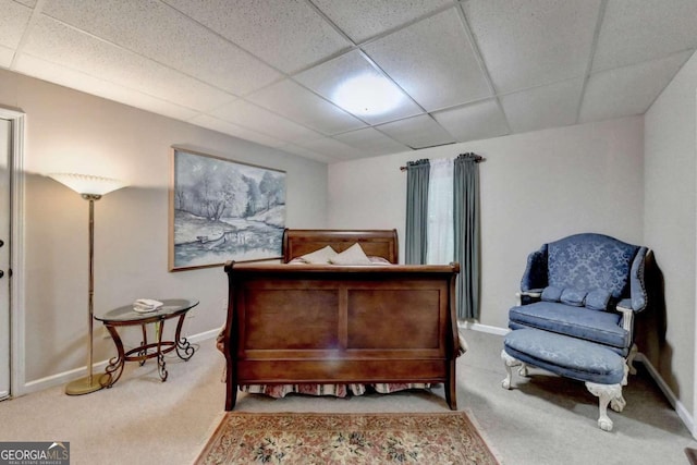 carpeted bedroom featuring a drop ceiling