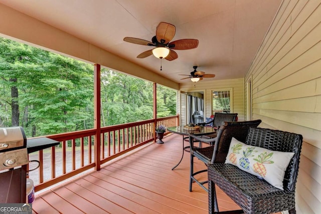 wooden terrace with ceiling fan and area for grilling