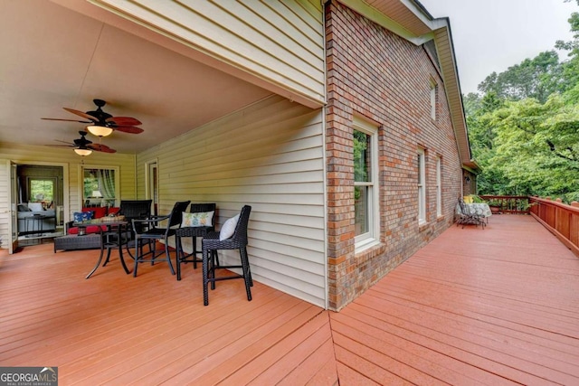 wooden deck featuring outdoor lounge area and ceiling fan