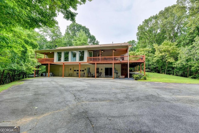 view of property with a front yard, ceiling fan, and a wooden deck